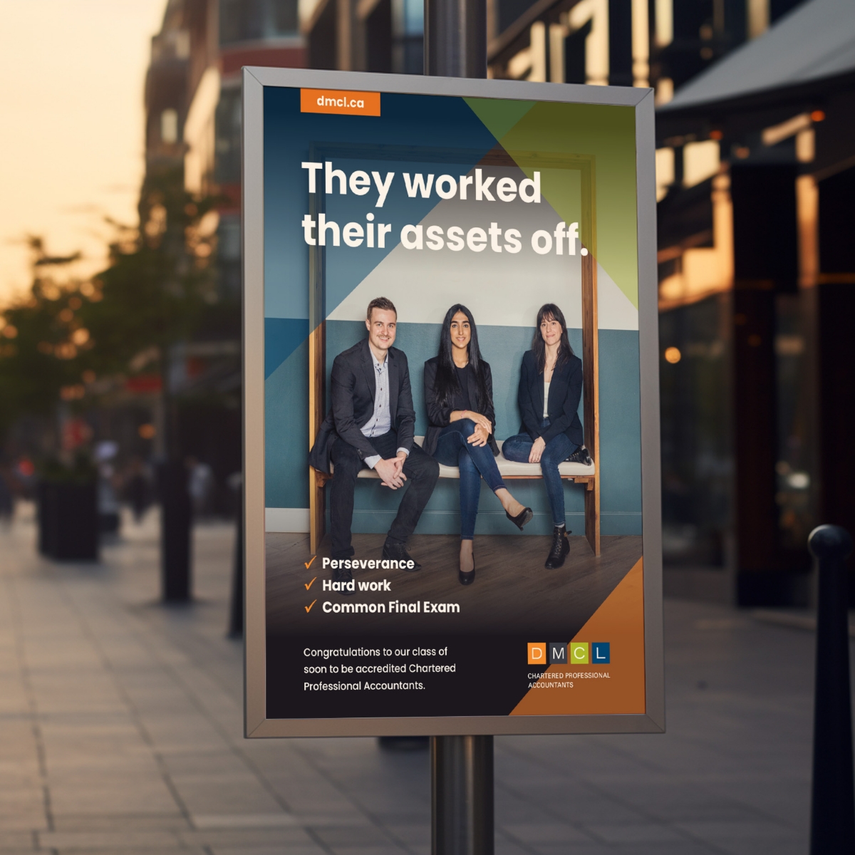 An outdoor advertising display in an urban street showcasing a DMCL Chartered Professional Accountants poster.