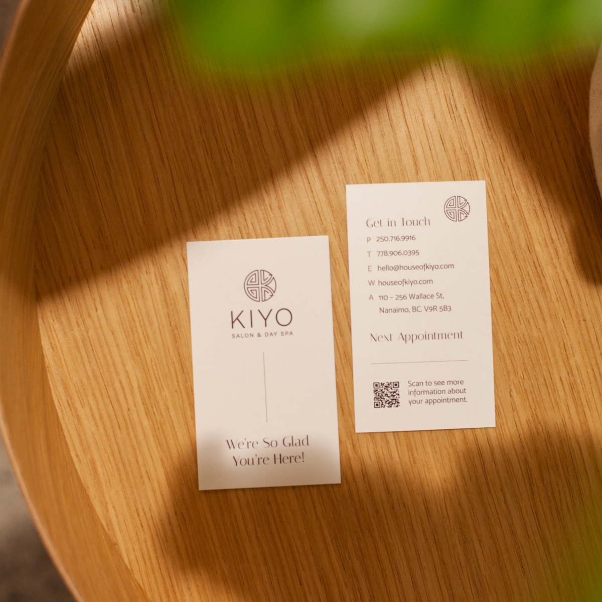 Custom business cards with modern sans serif font and sleek layout on a wooden tray.