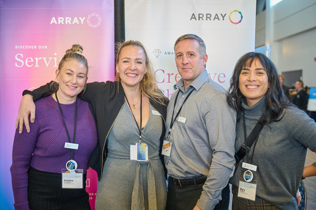 Array team members, Kristina, Sarah, Dan, and Myra, smiling for a photo at the 17th Annual State Of The Island Economic Summit infront of the Array booth.