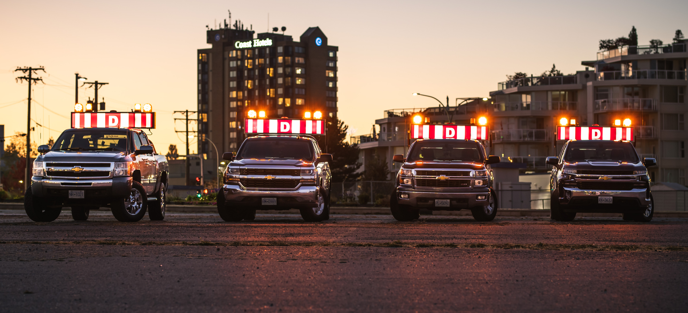 4 pilot trucks lined up in a parking lot in Nanaimo, BC.